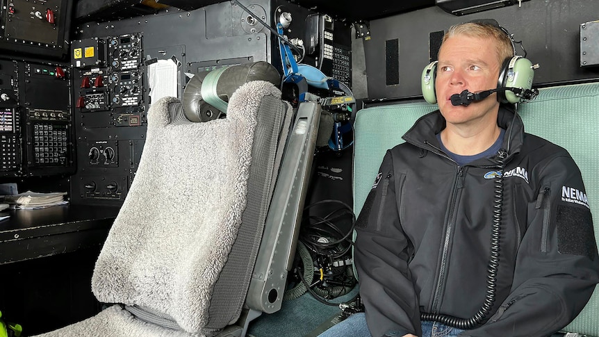 New Zealand Prime Minister Chris Hipkins sits in a helicopter with a headset on