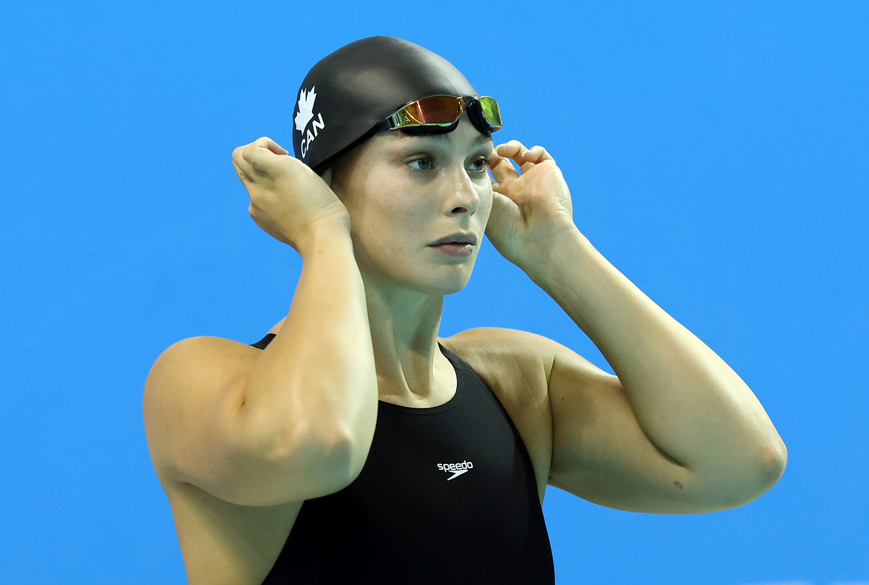 Penny Oleksiak adjusts her swimming cap before a race.