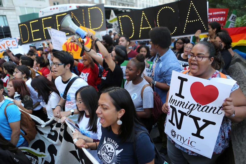 People march and chant slogans at a protest to protects immigrant children from deportation