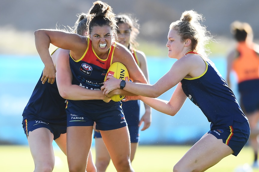 Ebony Marinoff of the Crows bursts through a tackle during an Adelaide Crows AFLW training session 