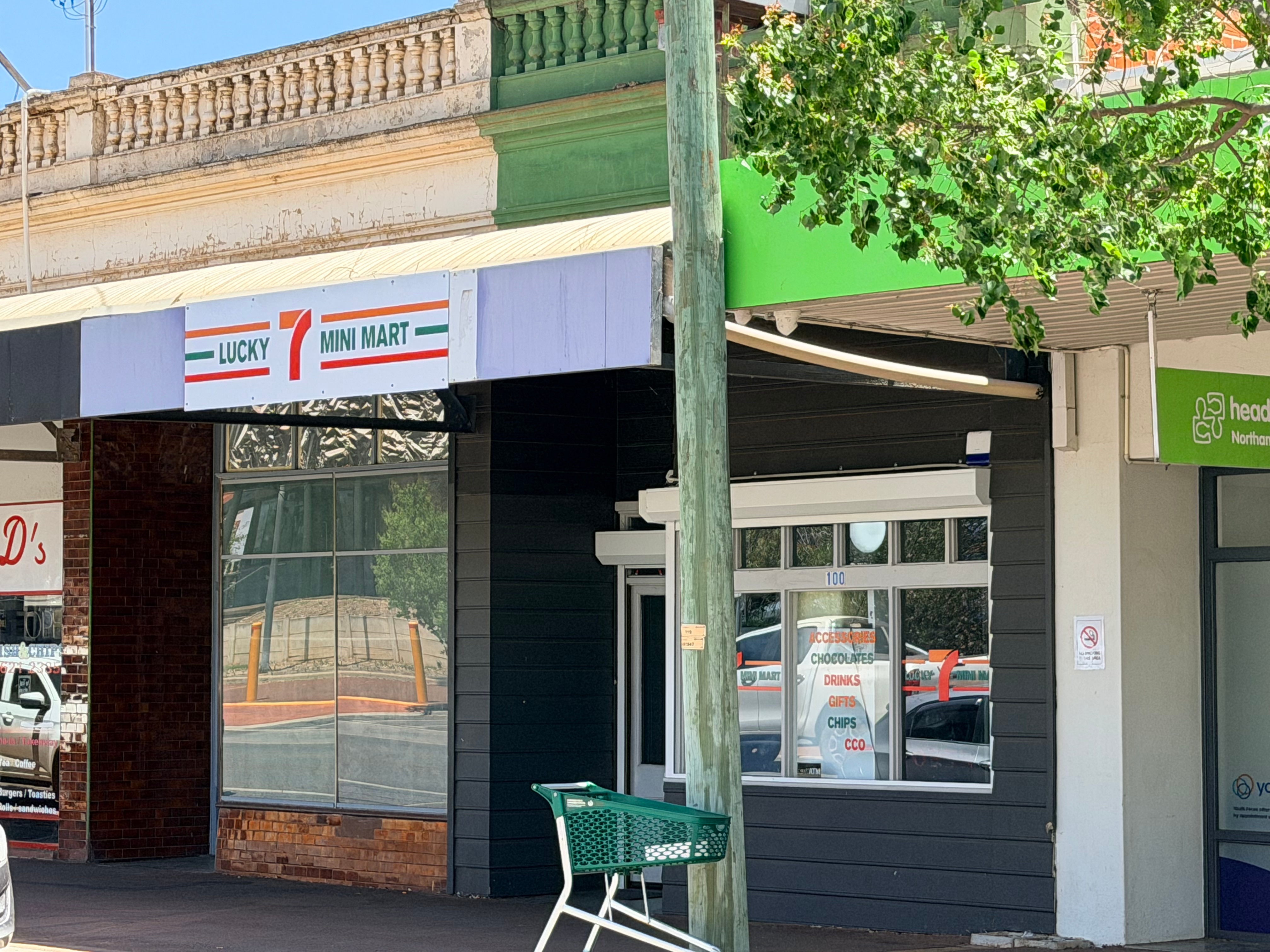 Una tienda en el patio con un cartel que dice “ "Minimercado Lucky 7".