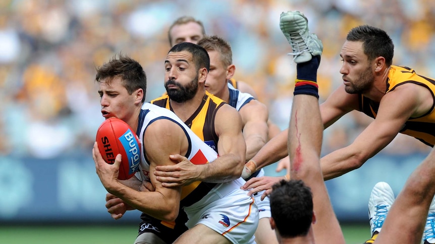 A footballer is tackled during an AFL game.