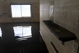 Flooded caravan park room with windows and benches just above water level