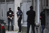 Police officers stand at the site of a shooting on Dries-Driesstraat at Forest-Vorst in Brussels.