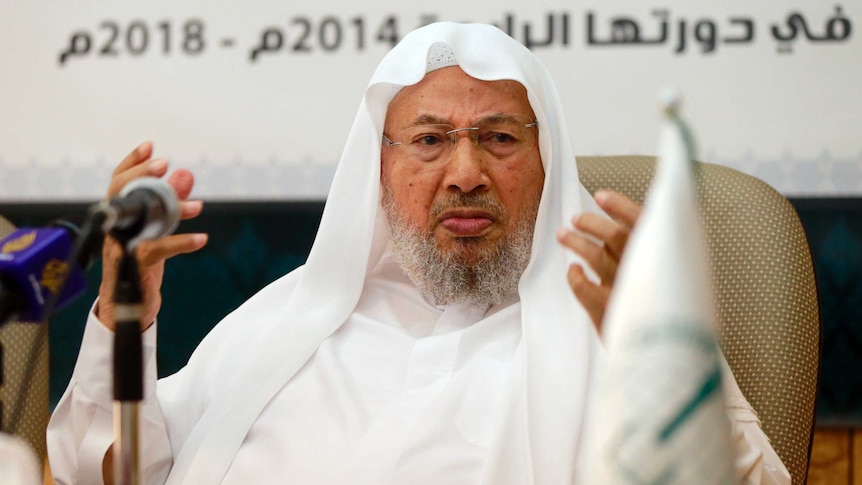 Muslim cleric Youssef al-Qaradawi speaks in a white robe. 
