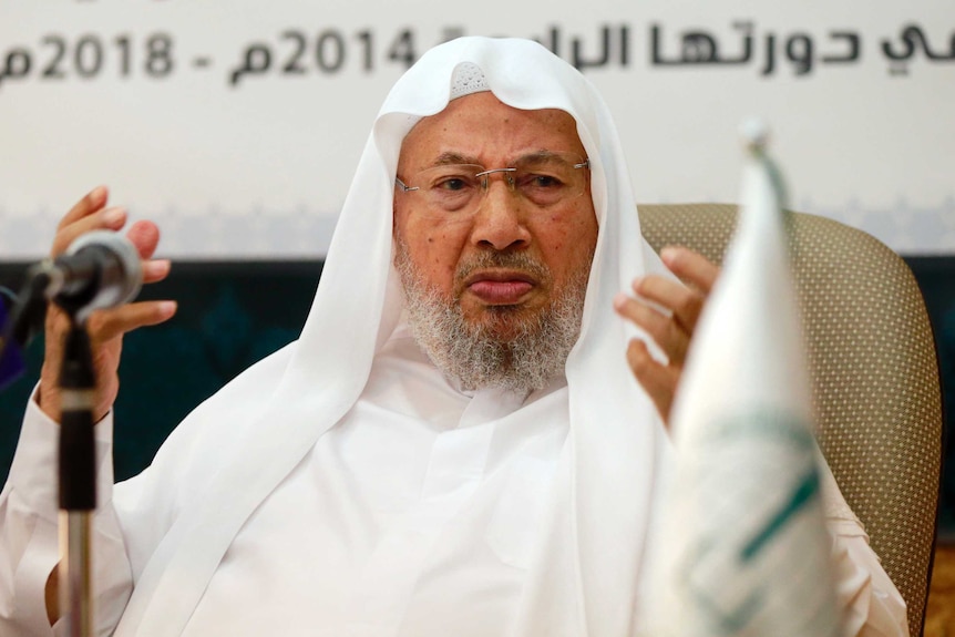 Muslim cleric Youssef al-Qaradawi speaks in a white robe. 