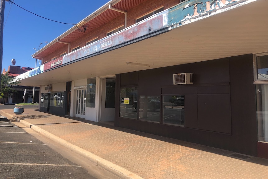 A row of empty shops with a for lease sign on it.