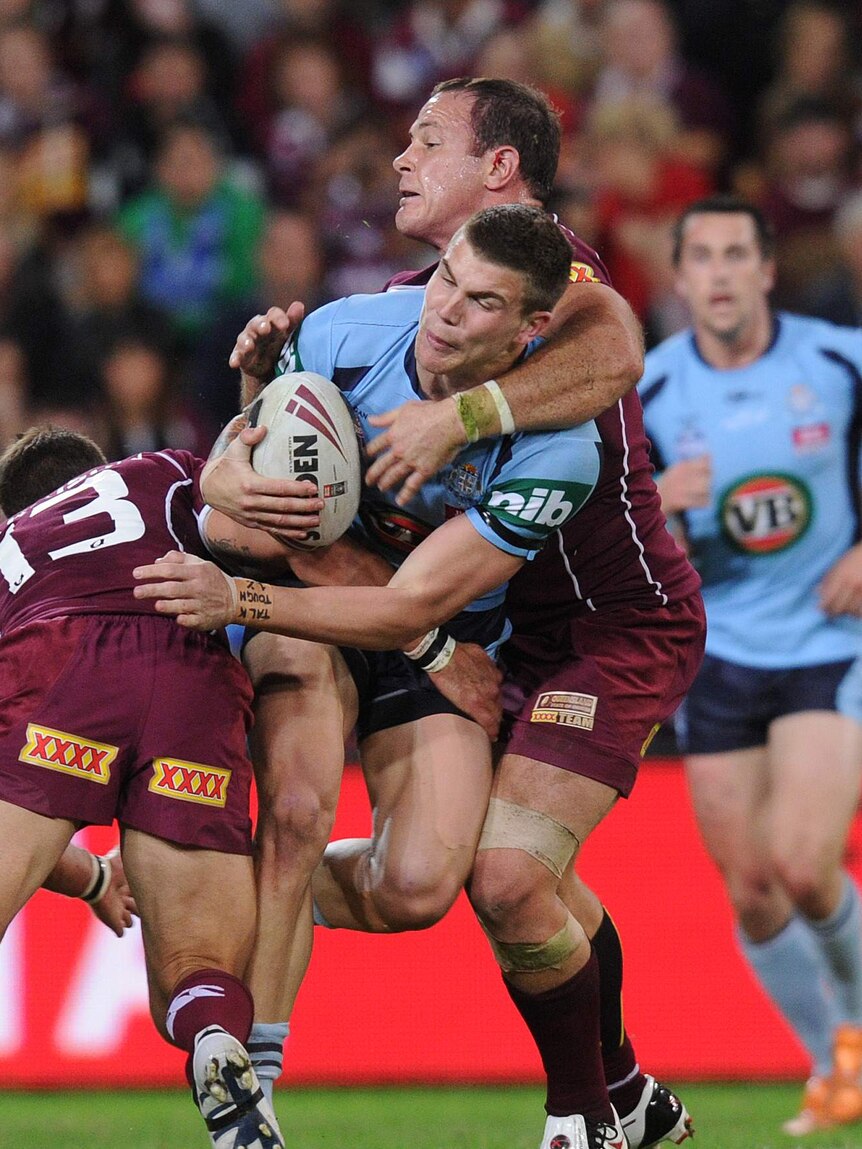 NSW player Josh Dugan is tackled by Queensland in Origin I, 2011 at Lang Park.