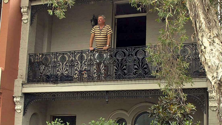 Chris Harpur looks out from the balcony of his house