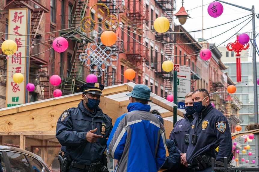 Several police officers talking to a man in New York City's Chinatown neighbourhood