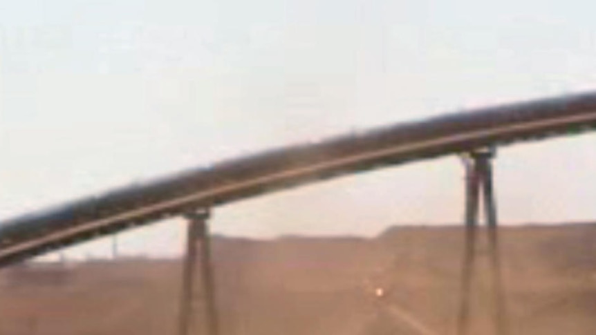 A long shot of FMG's Cloudbreak iron ore minesite with truck, and conveyor belt