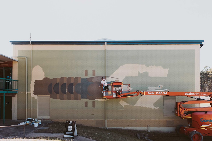 A giant mural of a marron on the side of a building.