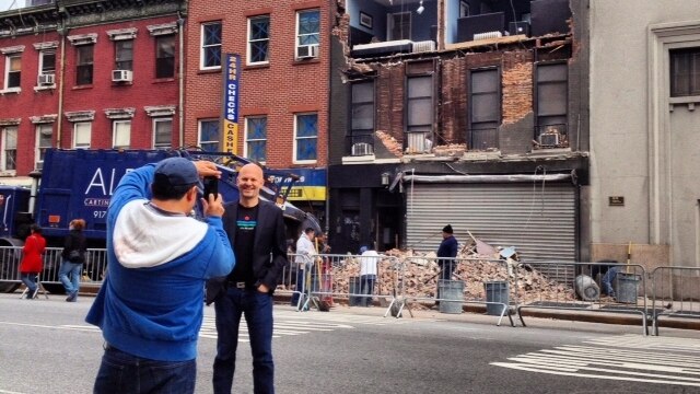 Tourists take photos of a ruined apartment block in New York City