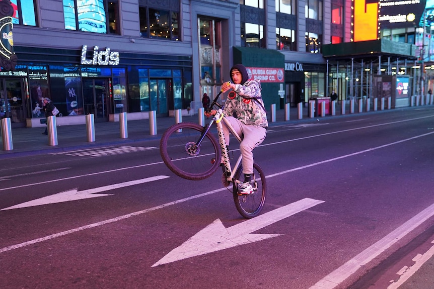 A man pops a wheelie in Times Square