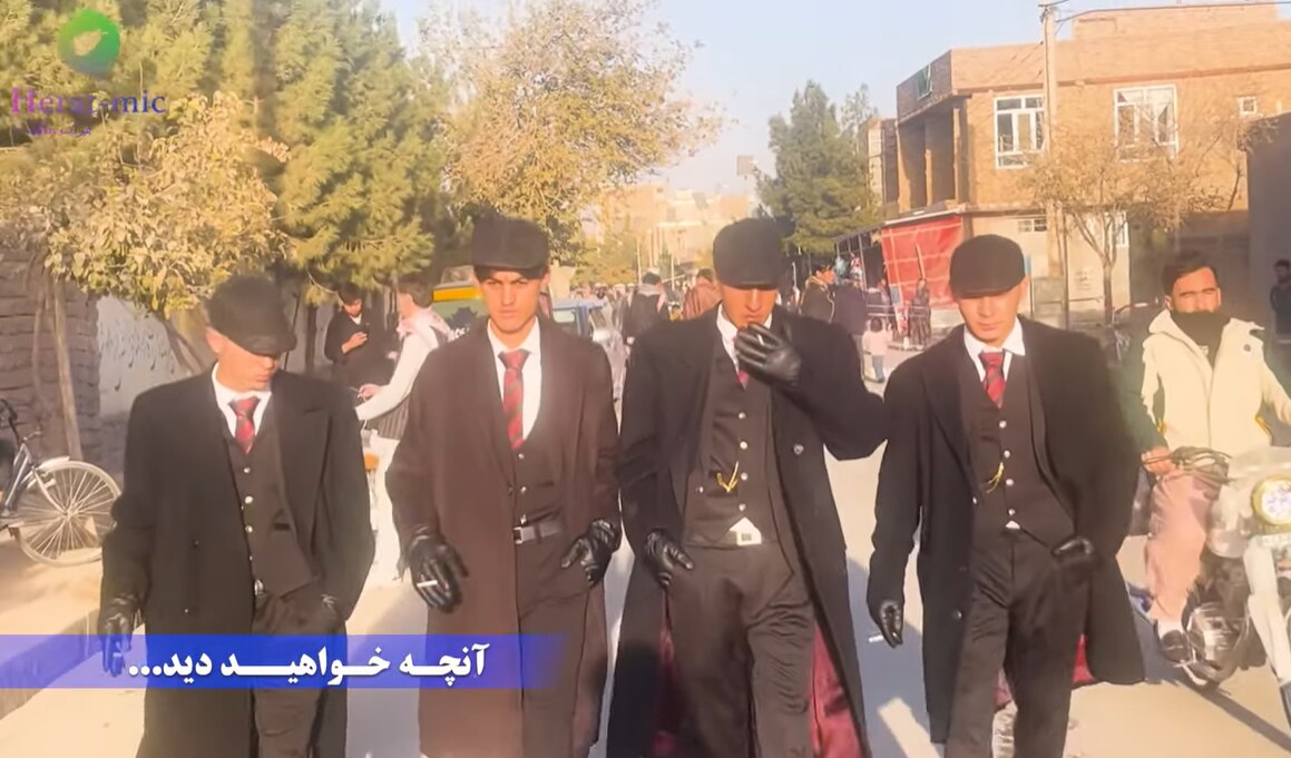 Una captura de pantalla de YouTube muestra a cuatro jóvenes vestidos con ropa de los años 20 caminando por una calle en Afganistán.