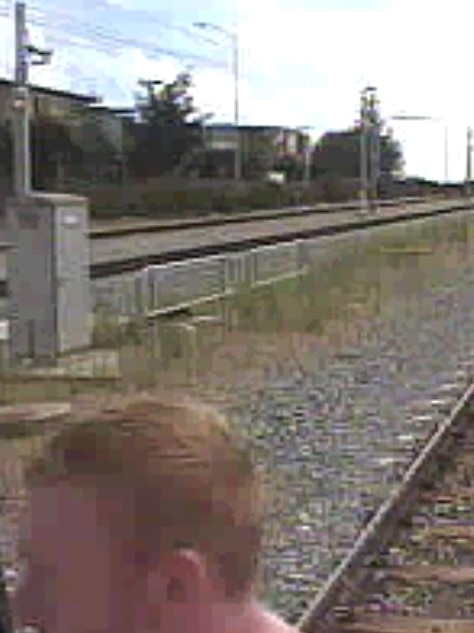 An image of a redheaded man with train tracks stretching out to the background.