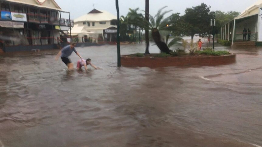 A girl falls in Broome's flooded streets.