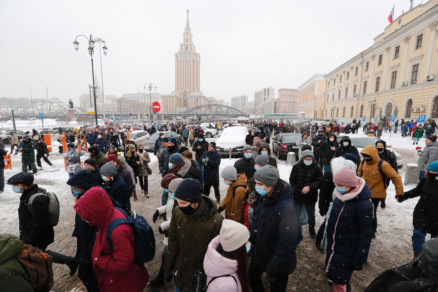 A large number of people walk on a street in snowy weather during a protest in Moscow, Russia.