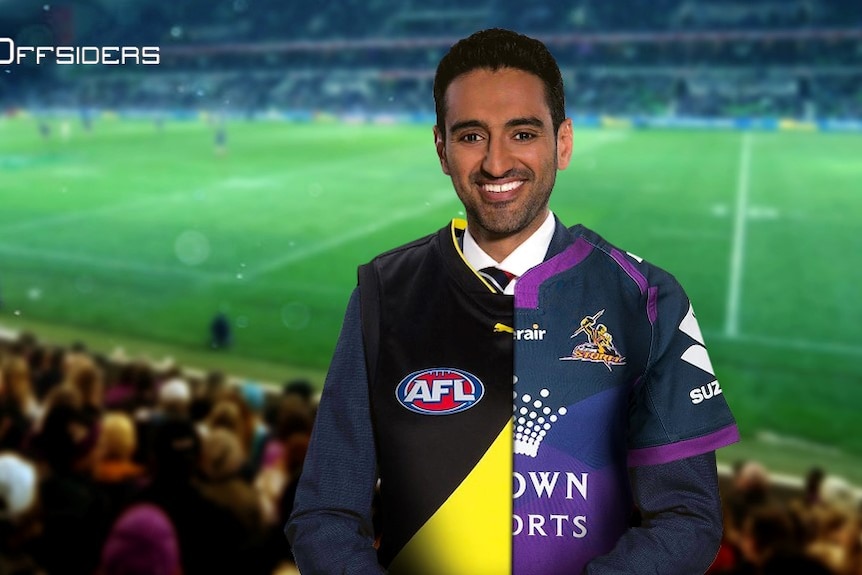 Waleed Aly standing in front of a rugby pitch wearing an AFL jersey and an NRL jersey.