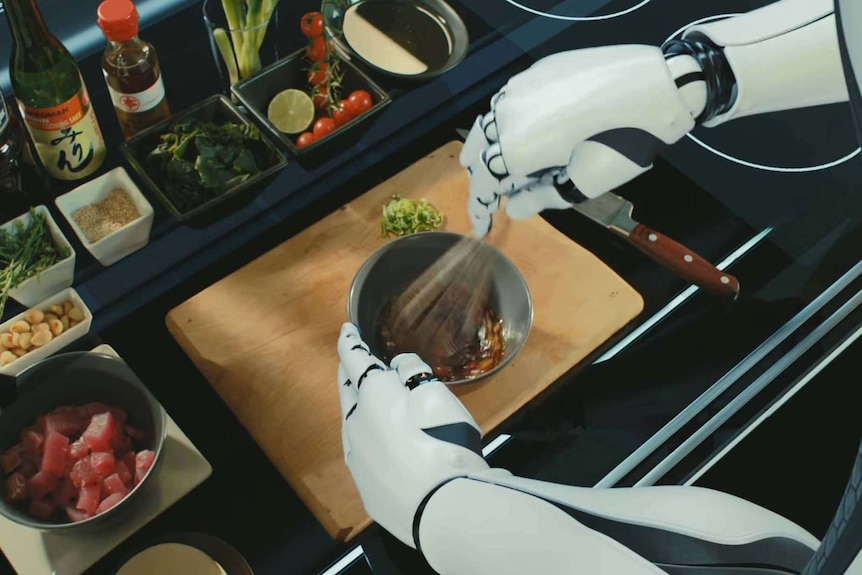 robot hands whisking a dish with other cooking materials surrounding.
