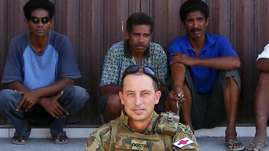 Dr Julian Fidge sits by the side of the road in East Timor