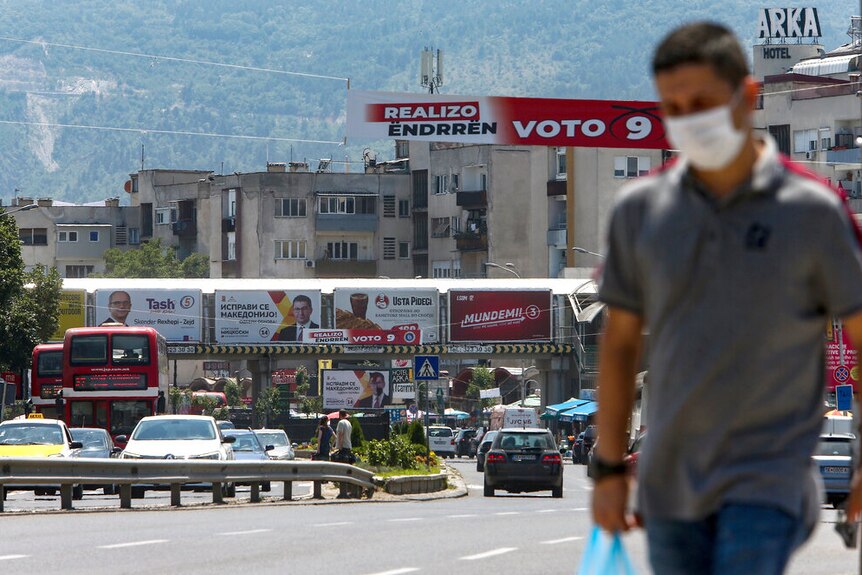 A North Macedonian street scene with election posters in the background