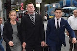 Shaun Kenny-Dowall walking outside the Downing Centre Local Court with two other people.