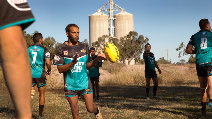 Team warms up in front of grain silos.