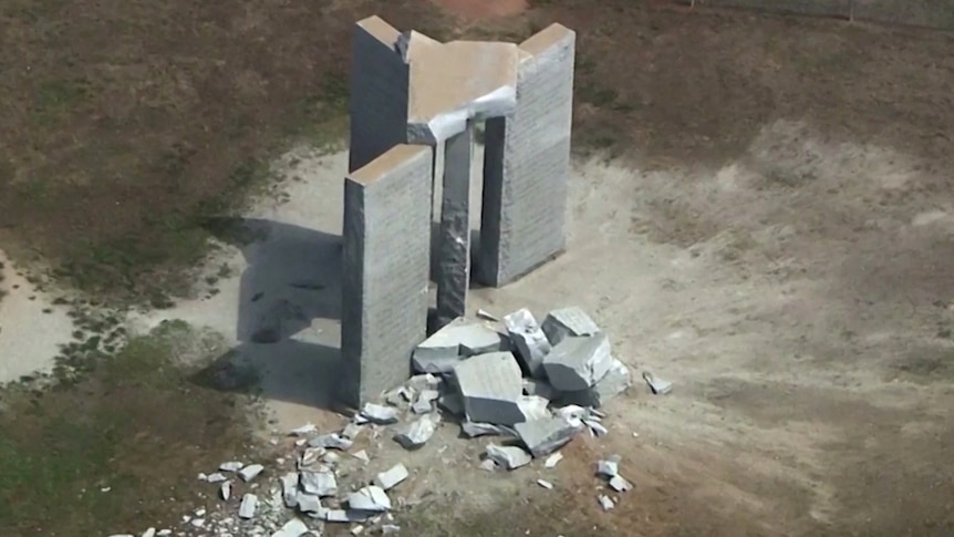 Rubble lies strewn about a concrete structure made up of three cement pillars