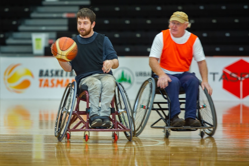 Wheelchair basketballer controls ball and gets away from opposing player