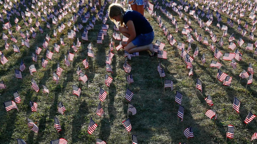Girl plants US flags to commemorate September 11 attacks