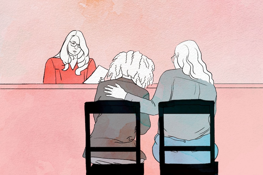 An illustration of two women from behind, sitting before a magistrate. One has their arm around the other. 