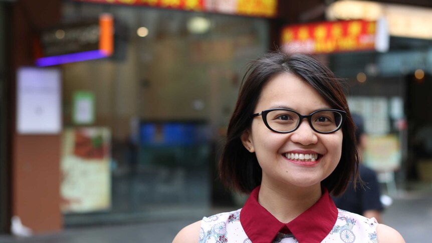 Alice Chu smiles at the camera while standing in front of shop windows