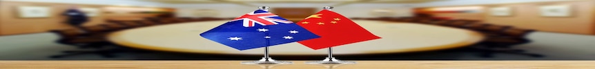 前台的澳大利亚和中国国旗背景是会议室的桌子。” class=