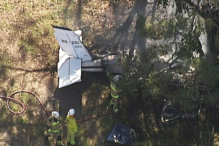 Firefighters at the scene of a small plane crash at Greenbank, south of Brisbane.