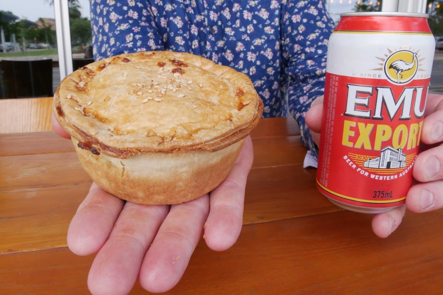 A close of up of a person holding a pie in one hand and a can of beer in the other.