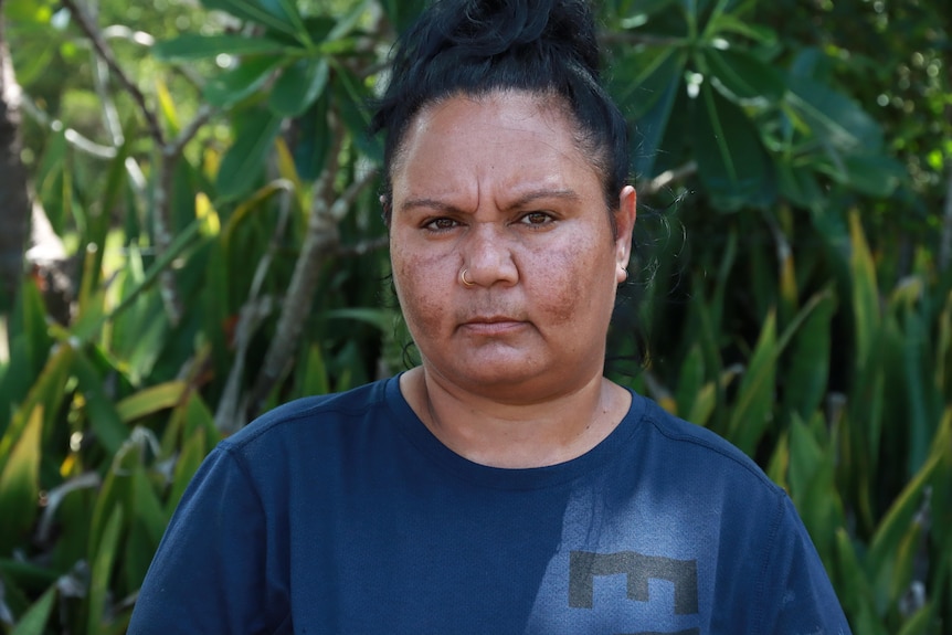 A young Indigenous woman looking at the camera with a stern expression.
