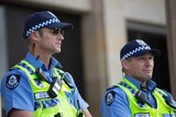 Two protective service officers stand outside WA Parliament House