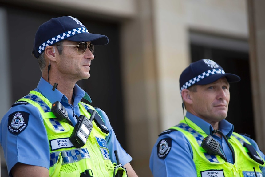 Two protective service officers stand outside WA Parliament House