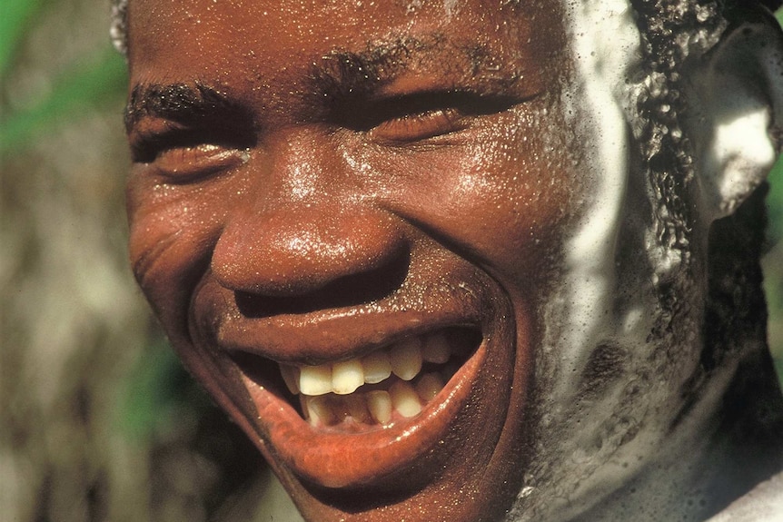 Portrait of smiling African man lathered in soap