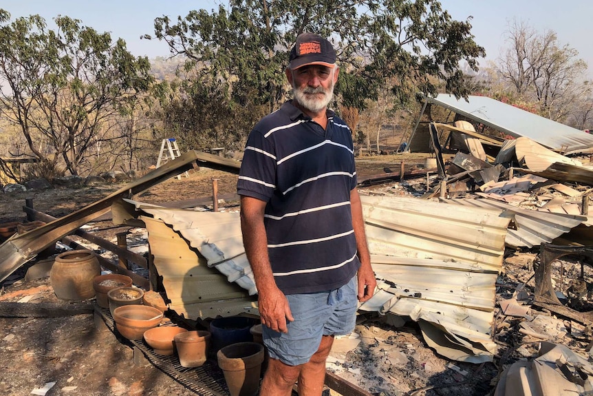 Wig Dailey stands in the ruins of his Kabra home.