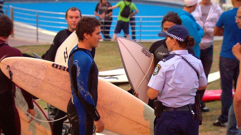 A police officer talks with a surfer after the attack.