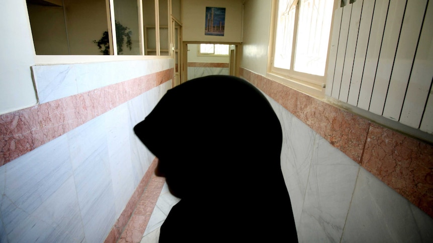 A female prison guard stands along a corridor in Tehran's Evin prison.
