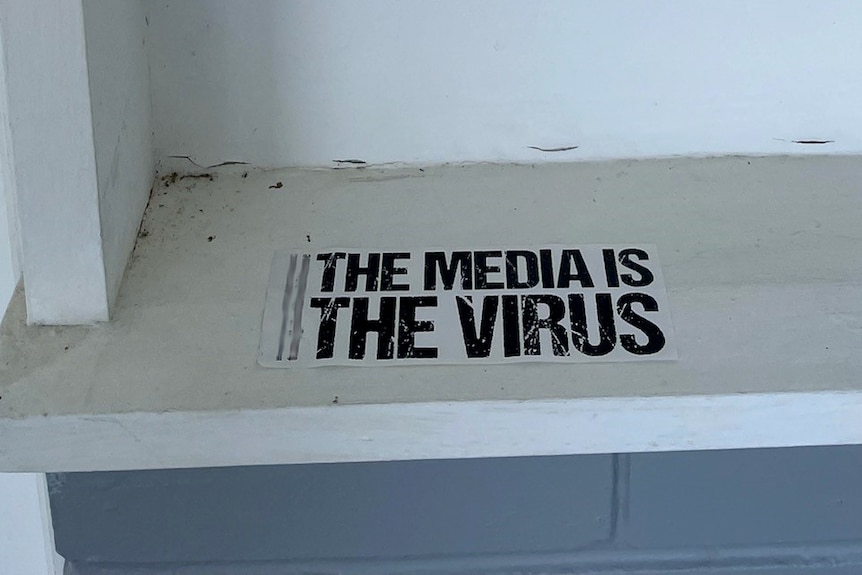A sticker saying  'The media is the virus' 