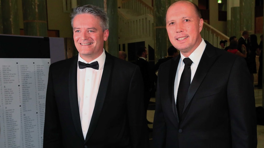 Mathias Cormann and Peter Dutton smile for the cameras in black tie attire.