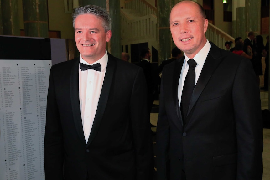 Mathias Cormann and Peter Dutton smile for the cameras in black tie attire.