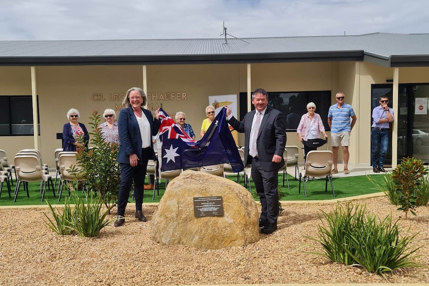 Senator Karen Grogan (holds an Australian flag with the Mayor of Kimba, Dean Johnson in front of the Kimba Medical Centre