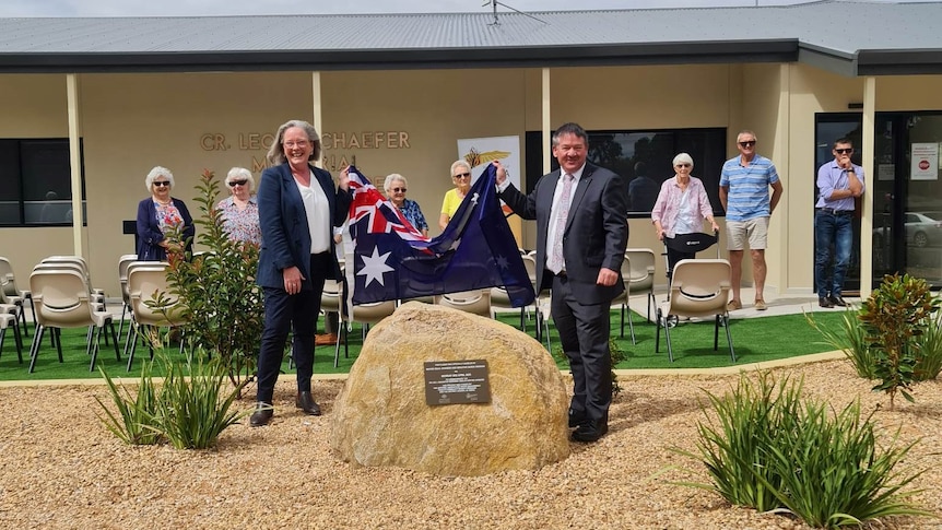 Senator Karen Grogan (holds an Australian flag with the Mayor of Kimba, Dean Johnson in front of the Kimba Medical Centre