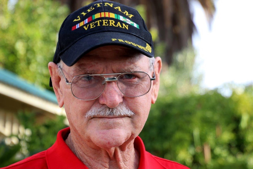 Headshot of a man wearing glasses and a hat that says Vietnam Veteran.