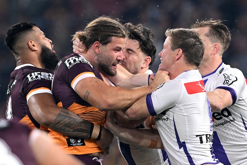 Two NRL players come together in a scuffle, with teammates for both coming to break it up.